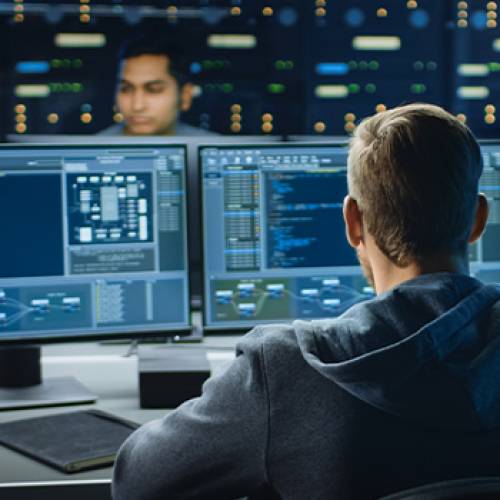 Technology workers writing code on computers