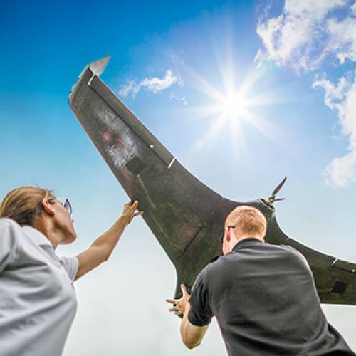 Man and woman hold up a UAS drone