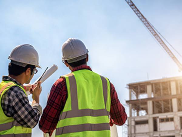Two construction workers surveying a commercial construction project