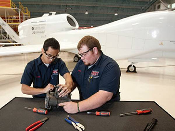 Two guys working on a UAS engine