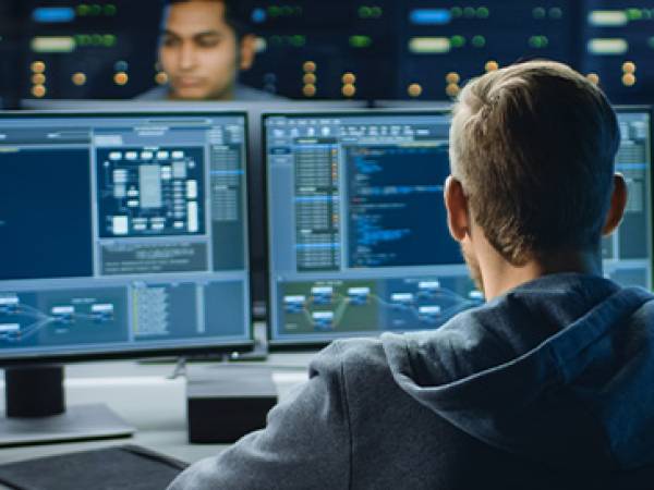 Technology workers writing code on computers