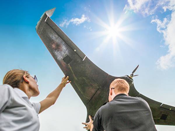 Man and woman hold up a UAS drone