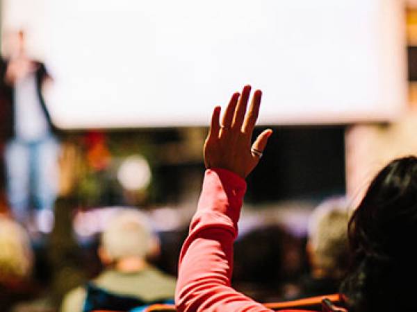 Woman raises hand at Million Cups event