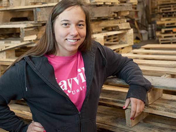Mayville student poses in front of pallets 