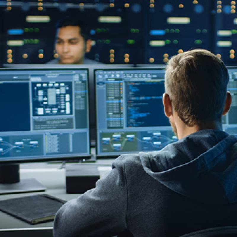 Technology workers writing code on computers