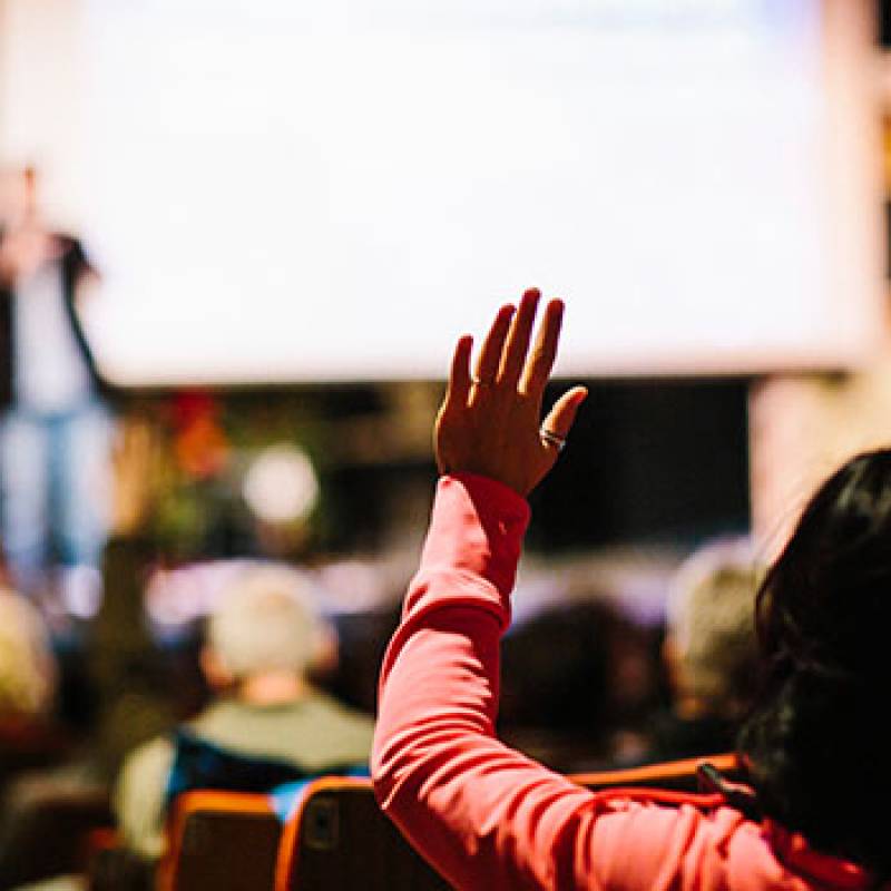 Woman raises hand at Million Cups event