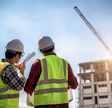 Two construction workers surveying a commercial construction project
