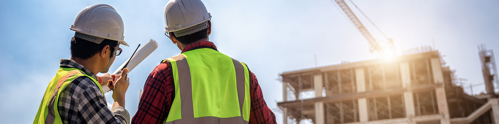 Commercial construction image showing two men in hard hats looking at a construction site