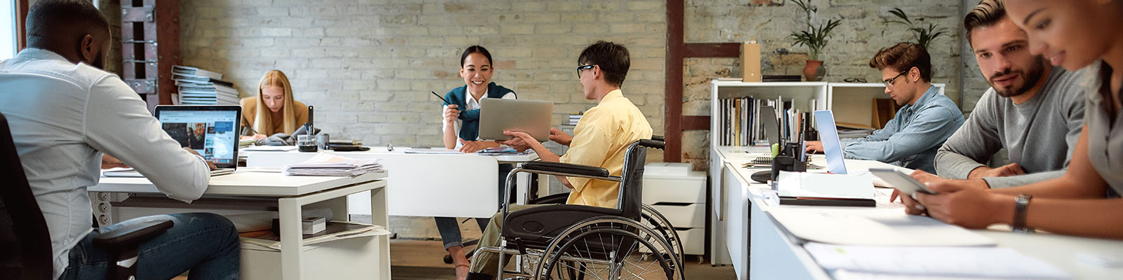 Office workers collaborating, one is in a wheelchair