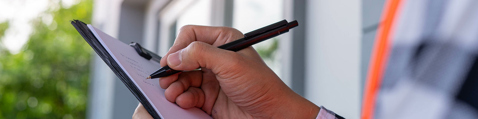 Home inspector marking a checklist on a clipboard