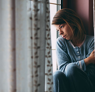 Woman at a shelter, staring out the window