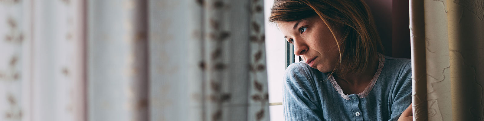 Woman at a shelter, looking out of a window