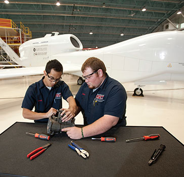 Two guys working on a UAS engine