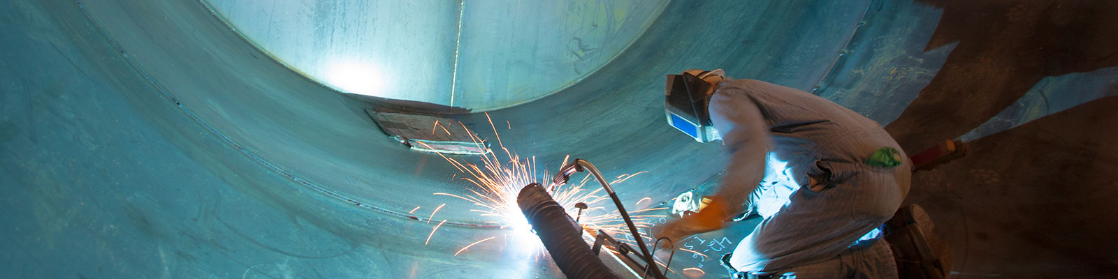Welder working inside of a large pipe