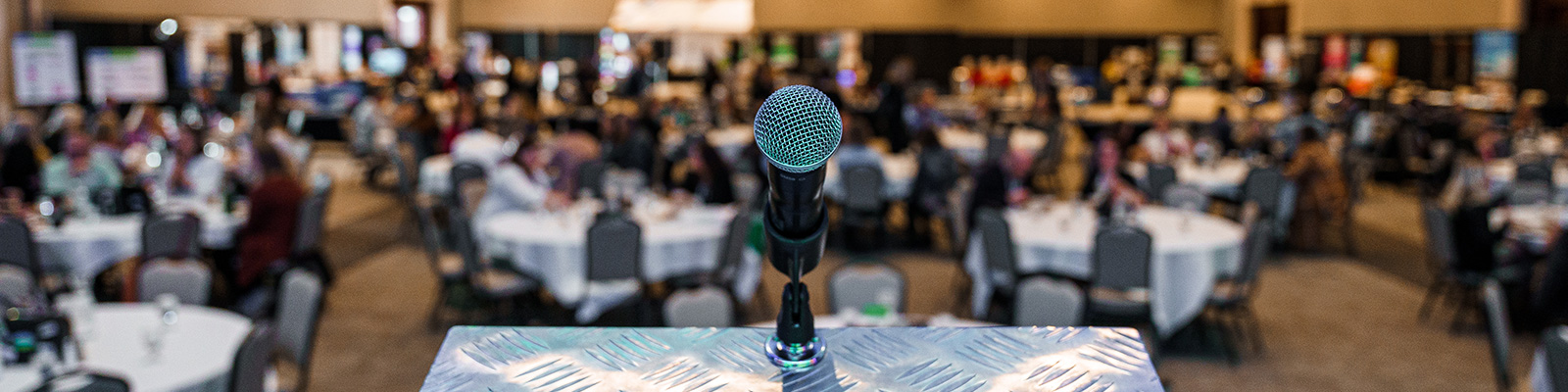 Overlooking the tables at travel conference behind the stage microphone