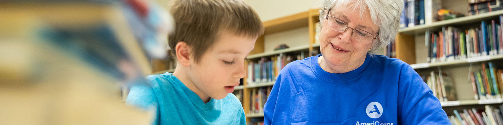 AmeriCorps senior volunteer helps a student