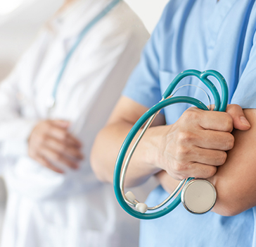 Closeup of two healthcare workers holding stethoscopes 