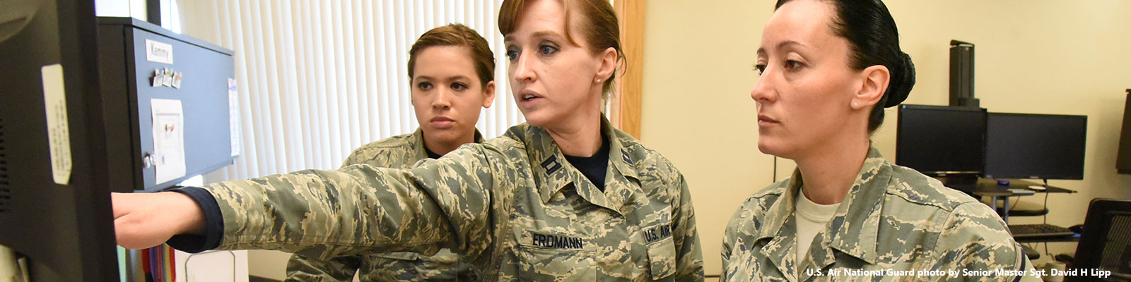 Soldiers analyze information showing on a computer monitor 