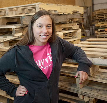 Mayville student poses in front of pallets 