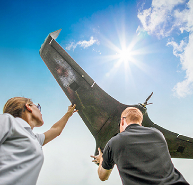 Man and woman hold up a UAS drone
