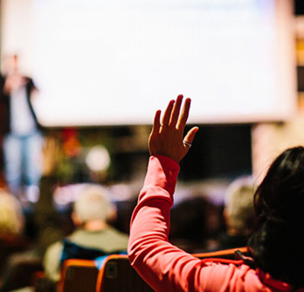 Woman raises hand at Million Cups event