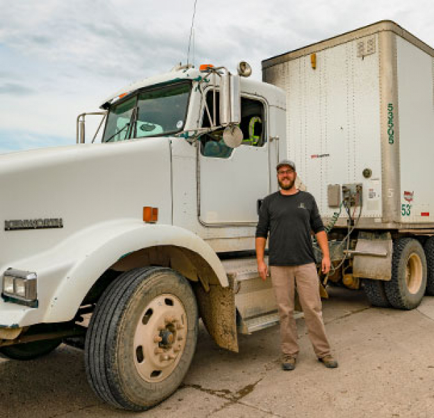 Driver stands in front of a commercial truck